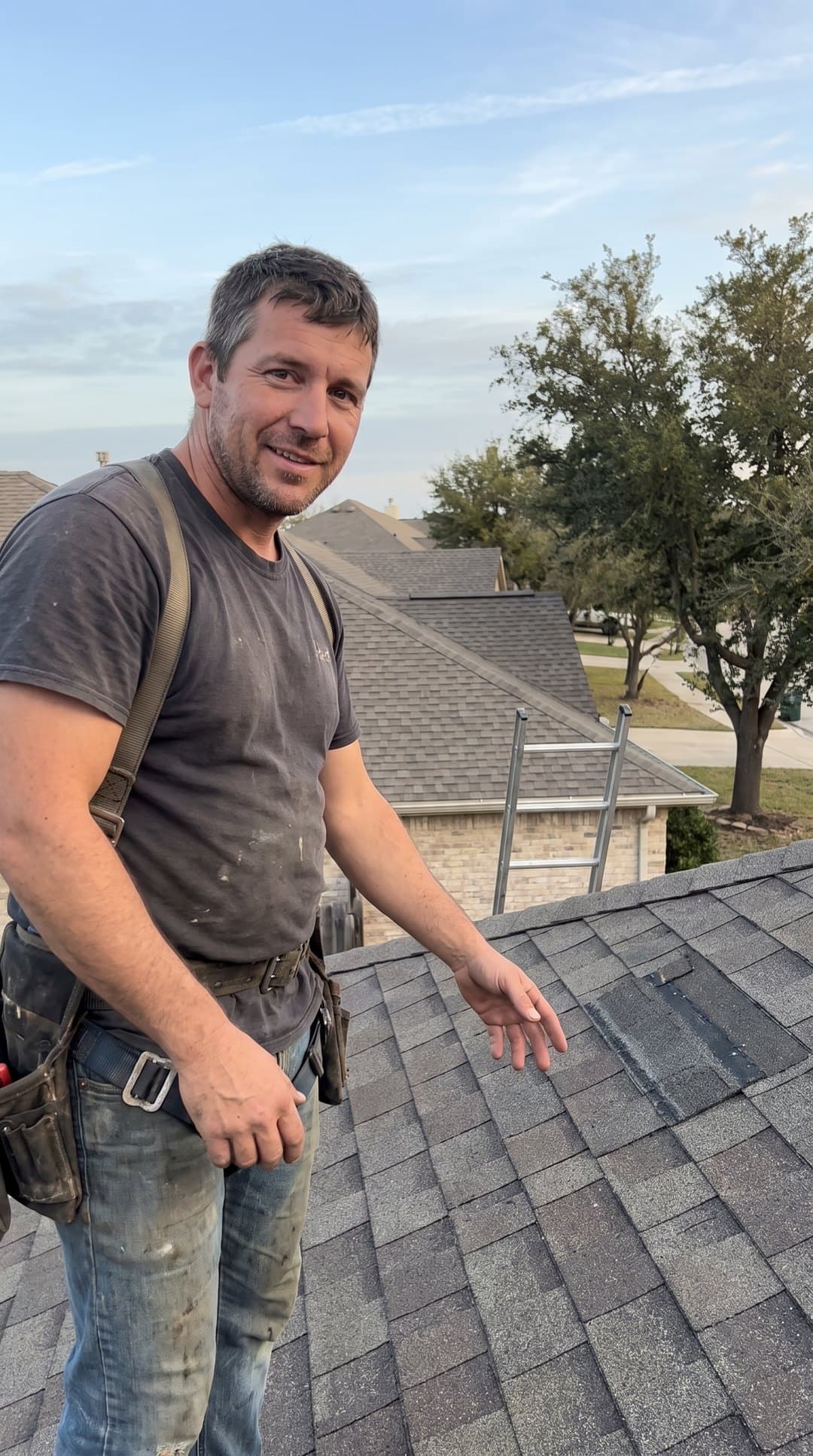 Roofer talking to the camera on a shingle roof on a clear morning